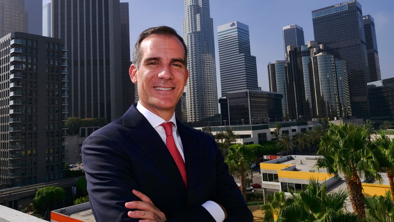 In this Aug. 23, 2018, file photo, Los Angeles Mayor Eric Garcetti poses in front of a sprawling downtown Los Angeles landscape. (AP Photo/Richard Vogel, File)