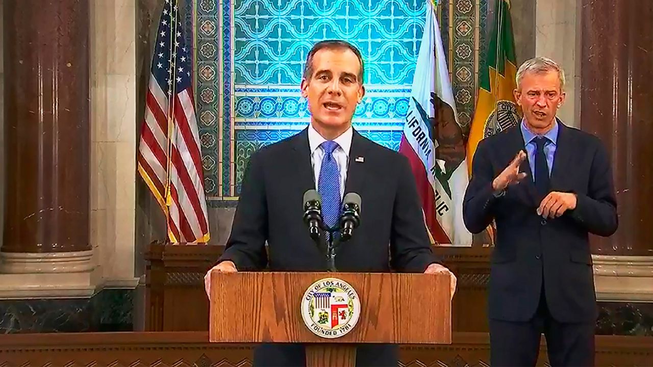 This photo from streaming video provided by the Office of Mayor Eric Garcetti shows Los Angeles Mayor Eric Garcetti giving his annual State of the City speech in an otherwise empty City Hall council chamber Sunday, April 19, 2020. He said thousands of Los Angeles city workers must take 26 furlough days, the equivalent of a 10 percent pay cut, over the course of the next fiscal year as the nation's second-largest city deals with the economic fallout from the COVID-19 crisis. Garcetti warned of an economic blow far worse than the 2008 recession, when city leaders laid off hundreds of workers and eliminated thousands of jobs. (Office of Mayor Eric Garcetti via AP)