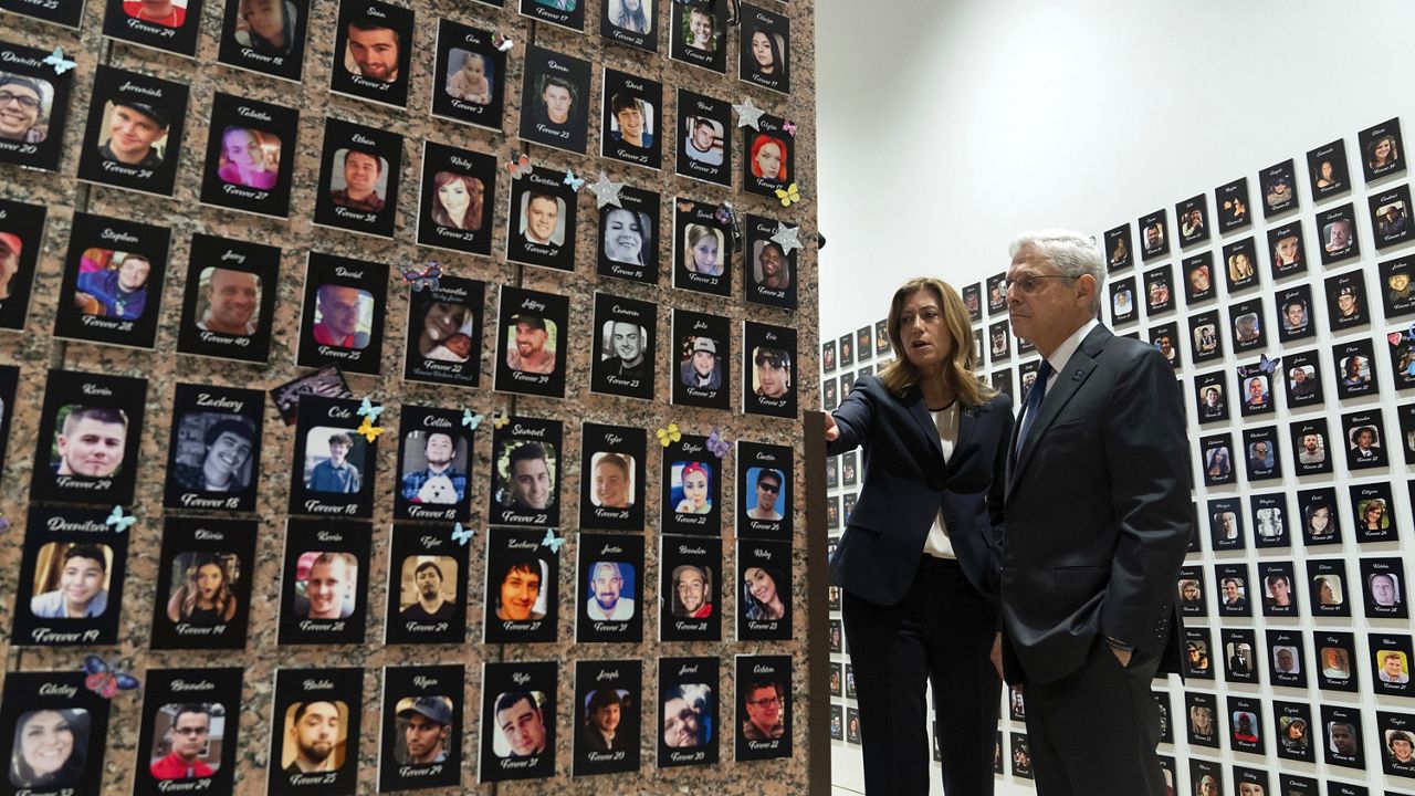 Attorney General Merrick Garland, accompanied by DEA Administrator Anne Milgram, looks Tuesday at photographs of people who died from drugs, during the second annual Family Summit on Fentanyl at DEA Headquarters in Washington. (AP Photo/Jose Luis Magana)