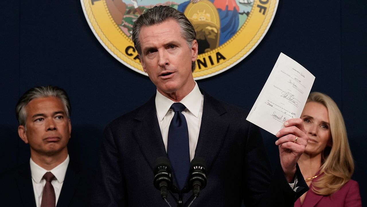 California Gov. Gavin Newsom displays a bill he just signed that shields abortion providers and volunteers in California from civil judgements from out-of-state courts during a news conference in Sacramento, Calif., June 24, 2022. (AP Photo/Rich Pedroncelli)
