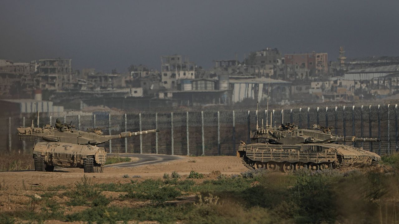 Israeli tanks stand near the Israel-Gaza border as seen from southern Israel Sunday, July 14, 2024. (AP Photo/Tsafrir Abayov)