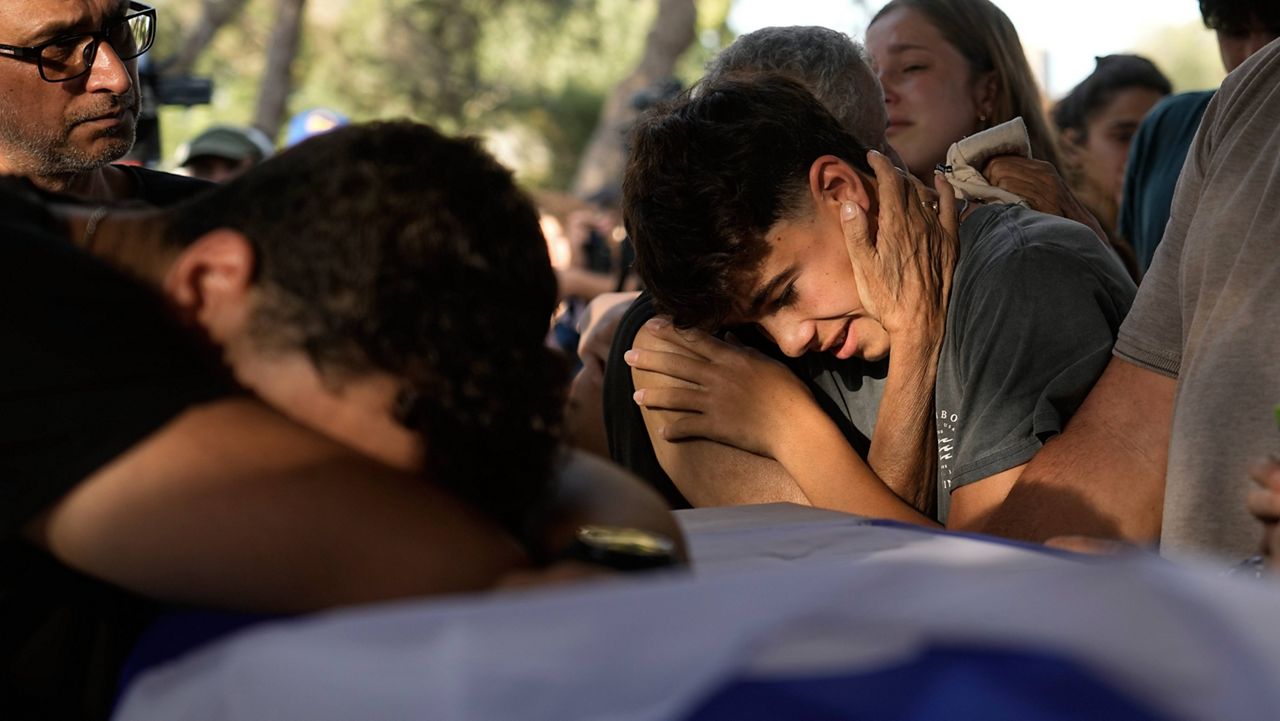 Family members mourn over the coffin of Yoram Metzger during his funeral at a cemetery of the kibbutz Nir Oz, southern Israel, Thursday, Aug. 22, 2024. (AP Photo/Tsafrir Abayov)