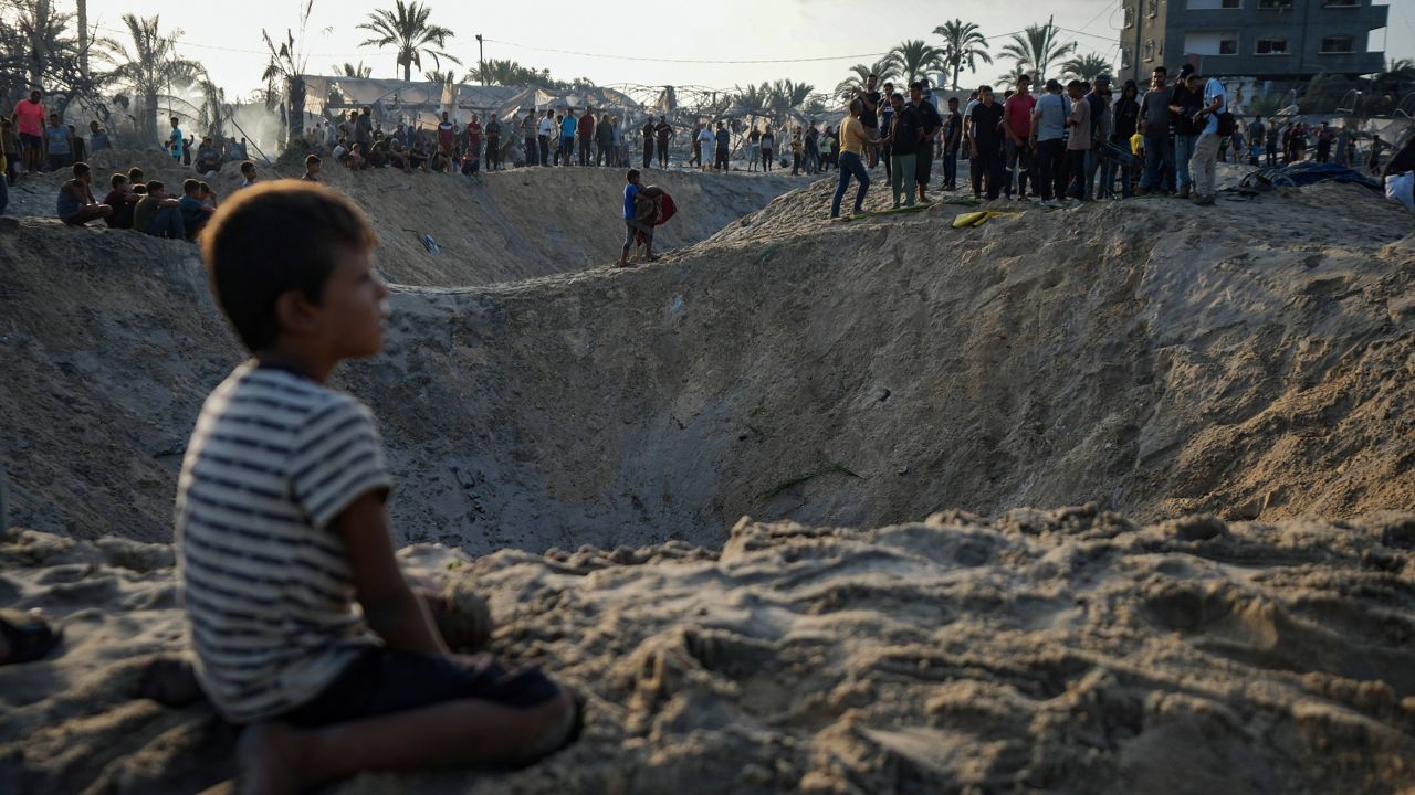 Palestinians look at the destruction after an Israeli airstrike on a crowded tent camp housing Palestinians displaced by the war in Muwasi, Gaza Strip, Tuesday, Sept. 10, 2024. (AP Photo/Abdel Kareem Hana)