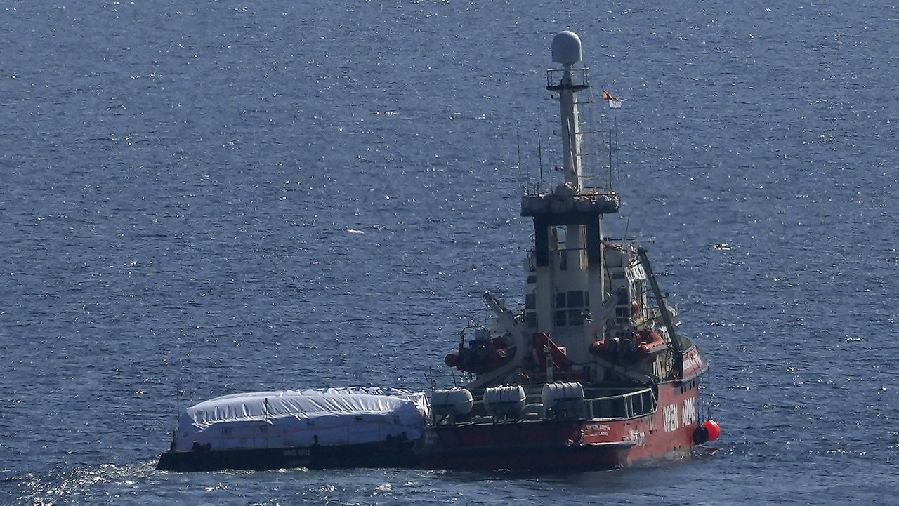 The ship belonging to the Open Arms aid group with aid on a platform ferry some 200 tons of rice and flour directly to Gaza, departs from the port from southern city of Larnaca, Cyprus, Tuesday, March 12, 2024. (AP Photo/Petros Karadjias) 