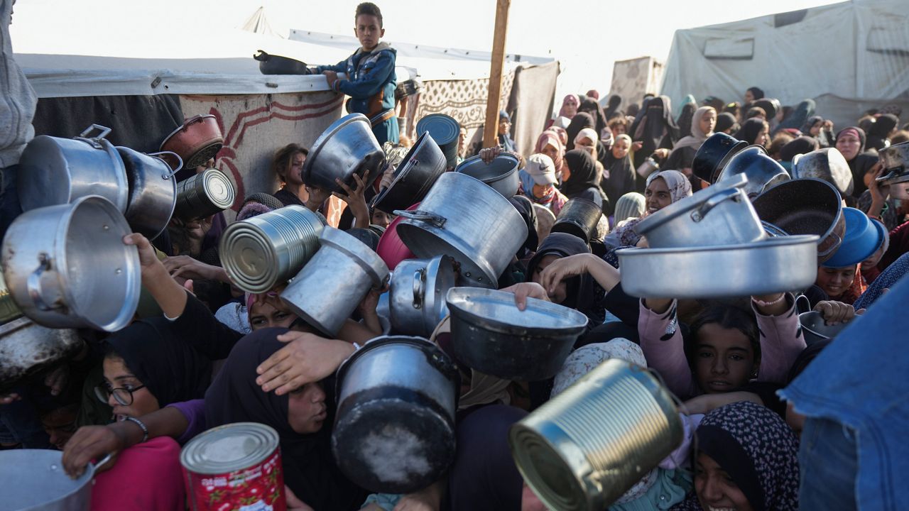 Palestinian women and girls struggle to reach for food at a distribution center in Khan Younis, Gaza Strip Friday, Dec. 6, 2024. (AP Photo/Abdel Kareem Hana, File)