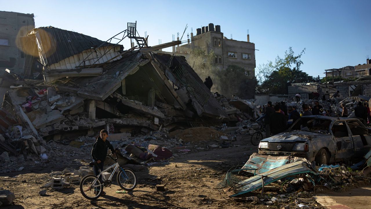 Palestinians search for bodies and survivors in the rubble of a residential building destroyed in an Israeli airstrike, in Rafah, southern Gaza Strip, Friday, Dec. 15, 2023. (AP Photo/Fatima Shbair)