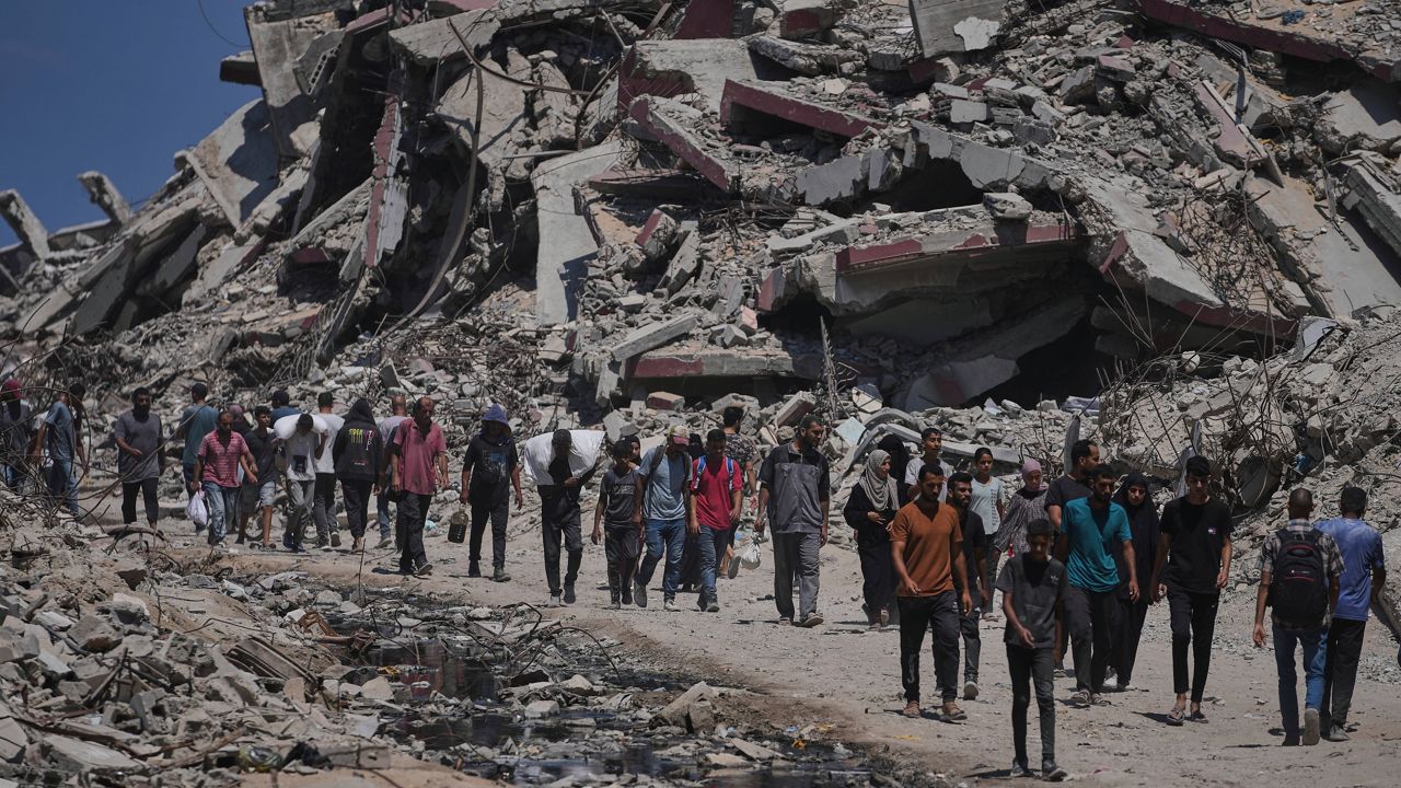Palestinians carry sacks of humanitarian aid unloaded from trucks convoy that had been heading to Gaza City, in the northern Gaza Strip Sunday, July 20, 2025. (AP Photo/Jehad Alshrafi)
