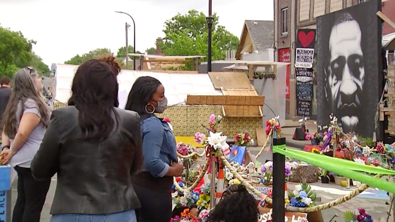 Visitors pay their respects at the spot George Floyd was killed by police, just a day before the one year anniversary of his death