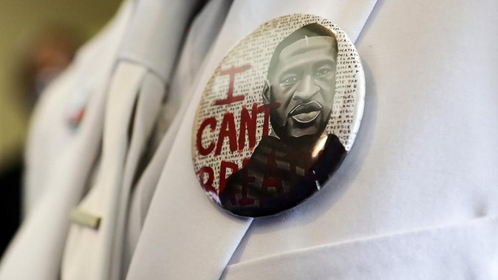 A button that reads "I can't breathe" adorns the jacket of a mourner before the funeral for George Floyd on Tuesday, June 9, 2020, in Houston. Political observers are watching whether Texas' governor will posthumously pardon Floyd for a 2004 arrest before the end of the year. (Godofredo A. Vásquez/Houston Chronicle via AP, Pool, File)