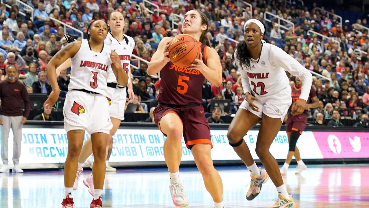 Virginia Tech guard Georgia Amoore (5) drives past Louisville guard Chrislyn Carr (3) and forward Liz Dixon (22) during an NCAA college basketball game of the Atlantic Coast Conference Tournament championship in Greensboro, N.C., on Sunday, March 5, 2023. (AP Photo/Chuck Burton)