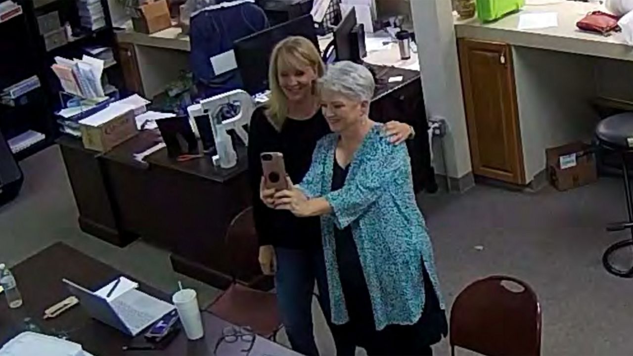 In this Jan. 7, 2021, image taken from Coffee County, Ga., security video, Cathy Latham, right, appears to take a selfie with a member of a computer forensics team inside the local elections office. (Coffee County, Georgia via AP)