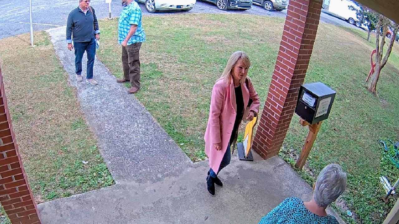 In this image taken from Coffee County, Ga., security video, Cathy Latham, bottom, chair of the Coffee County Republican Party, greets a team of computer experts at the county elections office in Douglas, Ga., on Jan. 7, 2021. (Coffee County via AP, File)