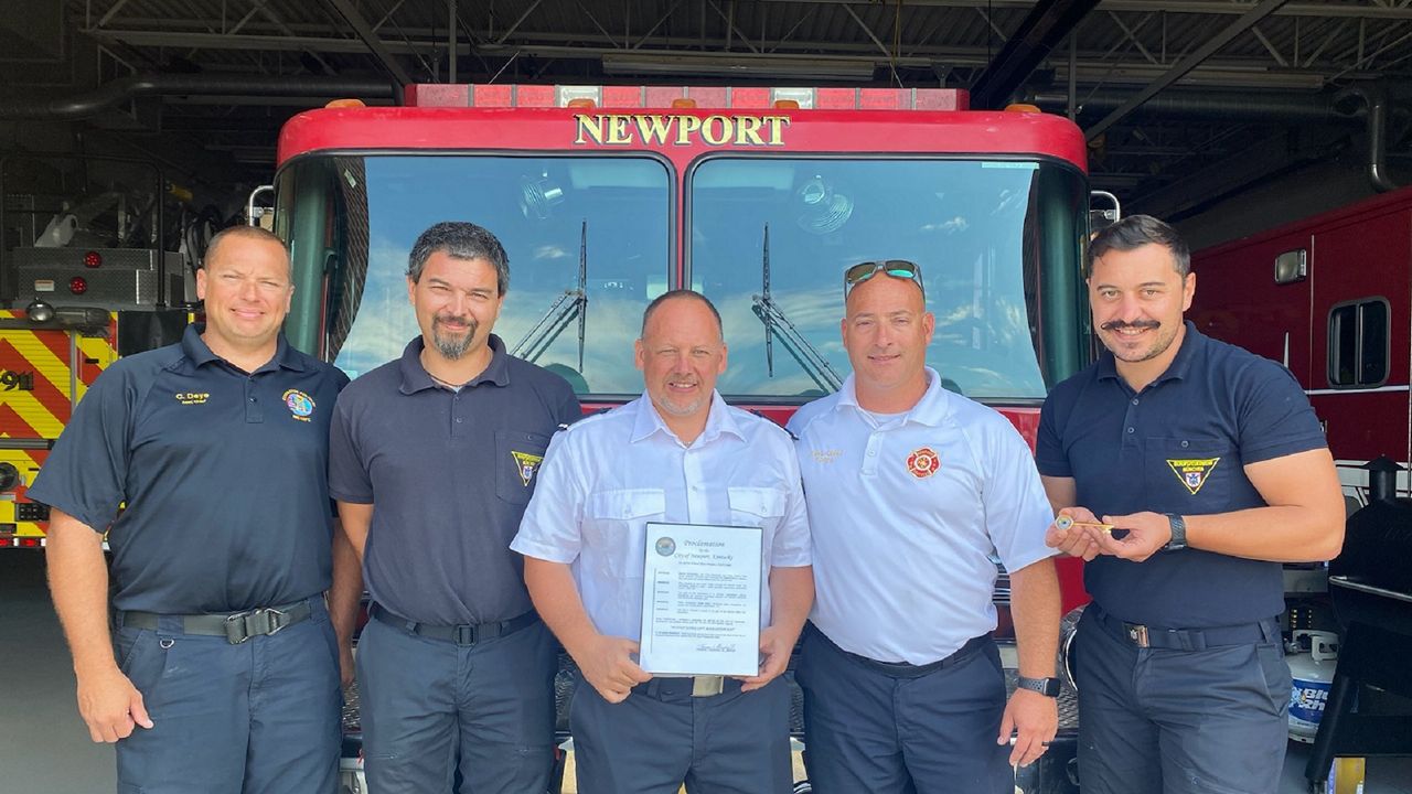 Three visiting firefighters from Munich, Germany, pose with leaders from the Newport (Kentucky) Fire Department. (Casey Weldon/Spectrum News 1)