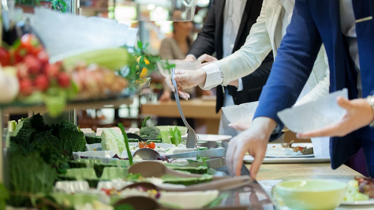 Stock image of people filling bowls at a salad bar. (Getty Images)