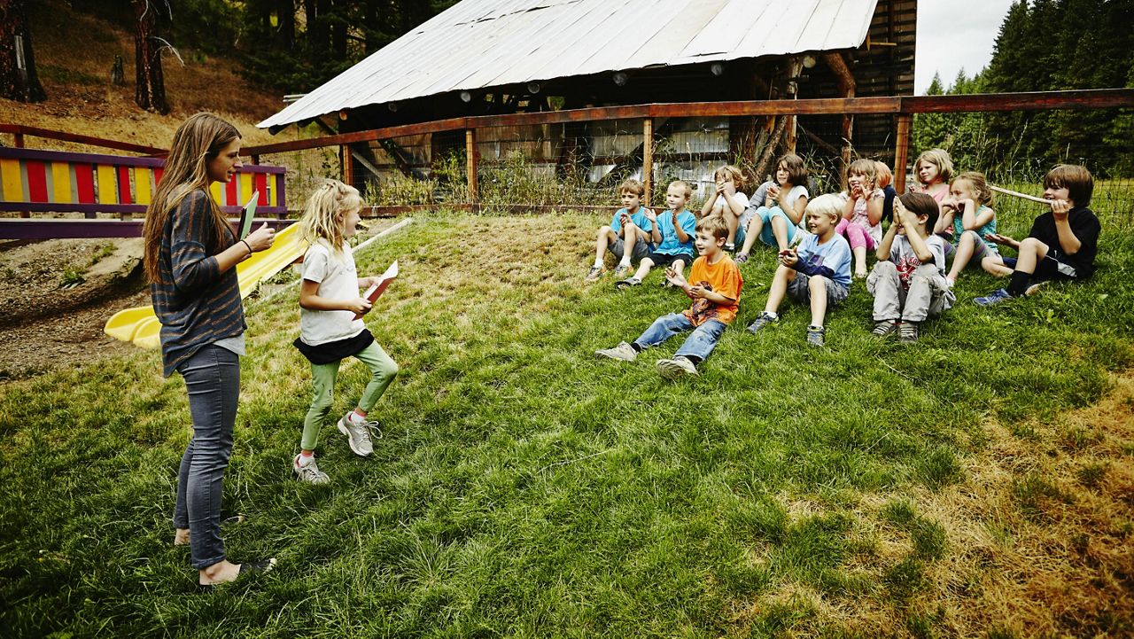 Stock image of a camp instructor working with children. (Getty Images)