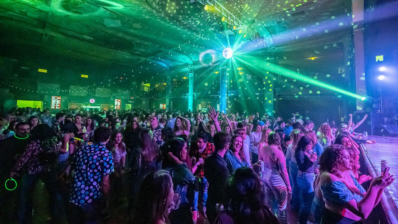 People dance in Turner Hall for a disco dance party