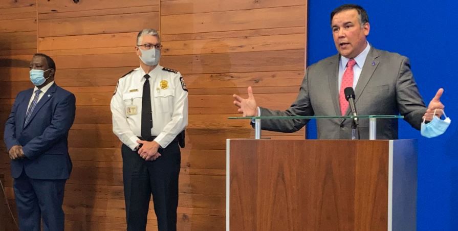 Columbus, Ohio, Mayor Andrew Ginther speaks during a news conference Wednesday about the fatal police shooting of 16-year-old Ma'Khia Bryant on Tuesday. Columbus Public Safety Director Ned Pettus (left) and interim Police Chief Michael Woods listen. Andrew Welsh-Huggins/AP