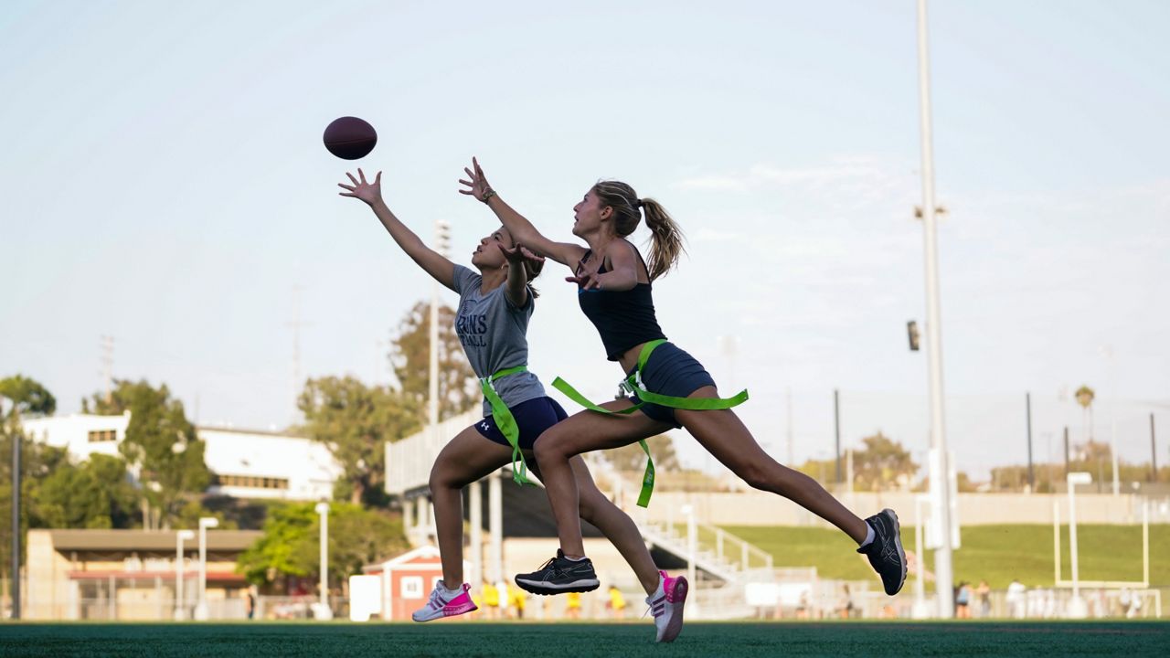 Syndel Murillo, 16, left, and Shale Harris, 15, reach for a pass as they try out for the Redondo Union High School girls flag football team on Thursday, Sept. 1, 2022, in Redondo Beach, Calif. (AP Photo/Ashley Landis, File )