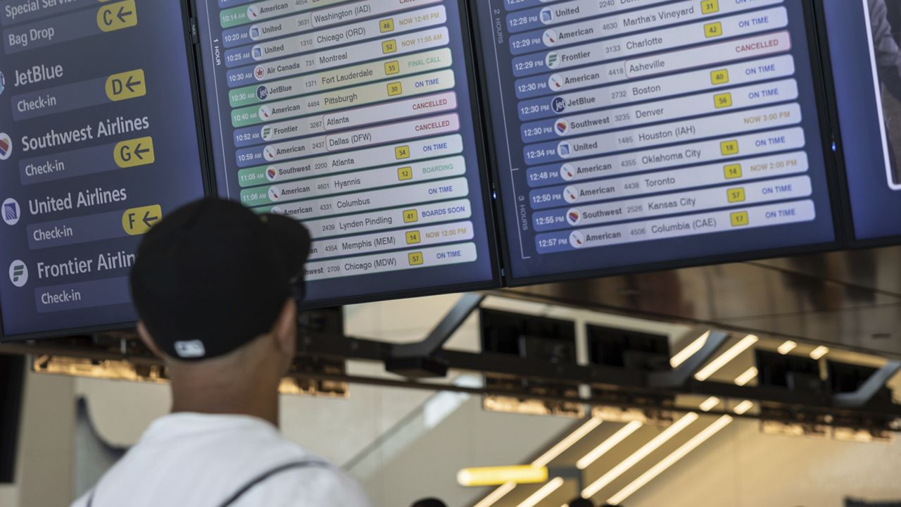 A person checks flight schedules on the screen at a departure floor of LaGuardia Airport in New York on Friday, July 19, 2024, after a faulty CrowdStrike update caused a major internet outage for computers running Microsoft Windows. (AP Photo/Yuki Iwamura)