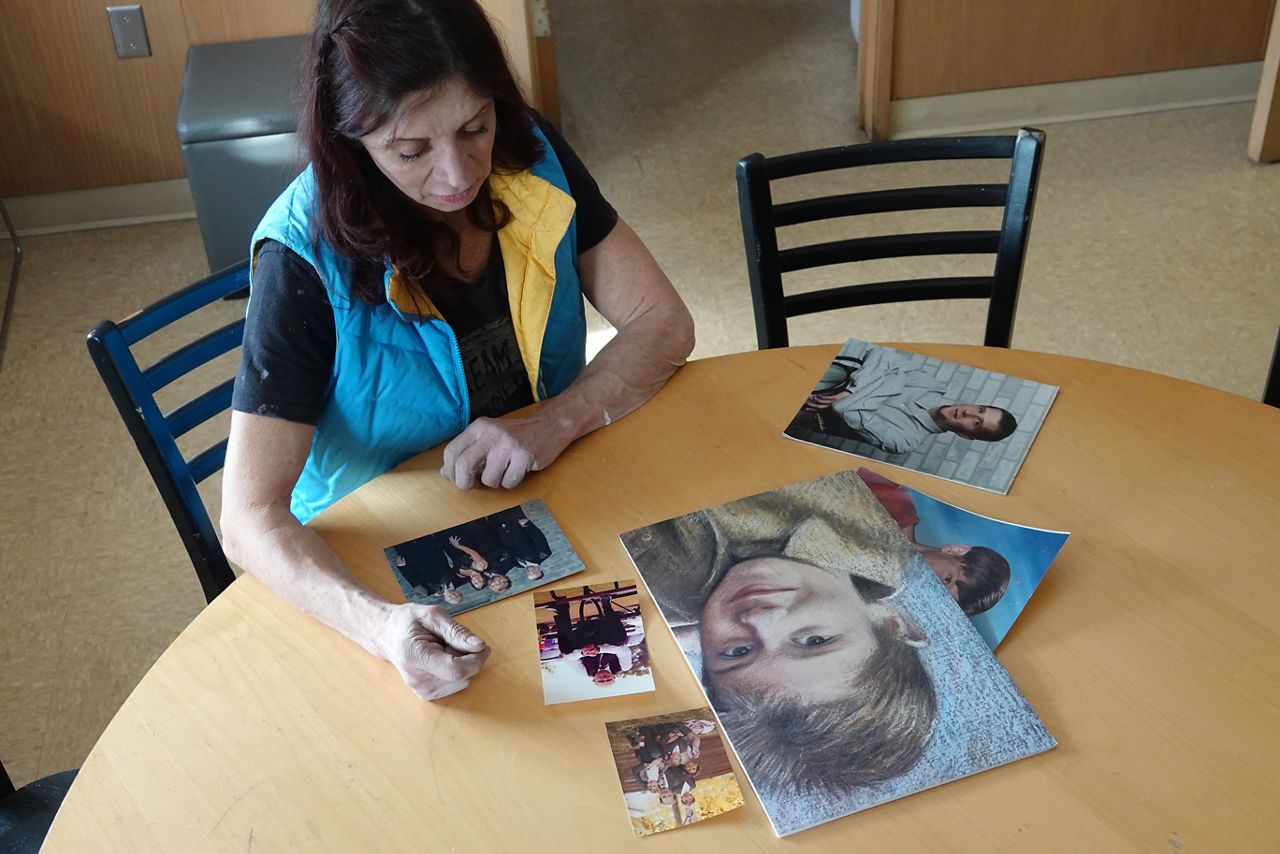 Gloria West looks at pictures of her son Elliott, who died from alcoholism. Photo courtesy of UW-Oshkosh FIXED Storytelling Project.