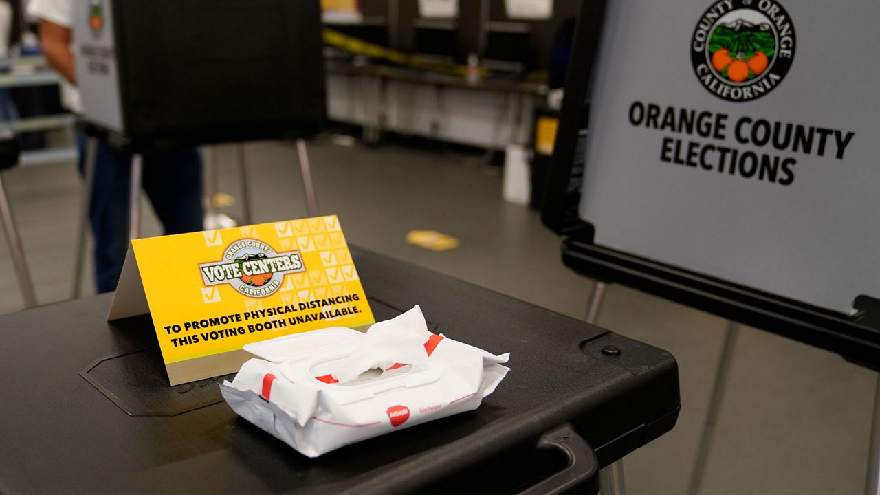 A sign designates physical distancing at a polling place Tuesday, Nov. 3, 2020, in Newport Beach, Calif. (AP Photo/Ashley Landis)