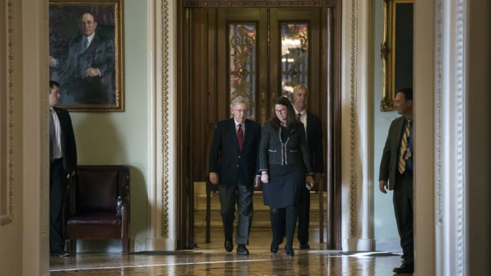 Senate Majority Leader Mitch McConnell, R-Ky, accompanied at right by Secretary for the Majority Laura Dove, walks to his office from the chamber as Republicans in the House and Senate plan to pass the sweeping $1.5 trillion GOP tax bill on party line votes, at the Capitol in Washington, Monday, Dec. 18, 2017. (AP Photo/J. Scott Applewhite)