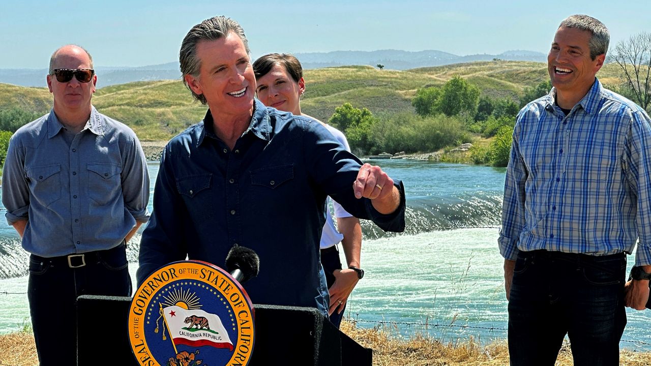 California Gov. Gavin Newsom speaks during a news conference in front of the Daguerre Point Dam on Tuesday, May 16, 2023, in Marysville, Calif. Local, state and federal officials plan to build a channel around the dam so threatened species of fish can access more habitat. (AP Photo/Adam Beam)