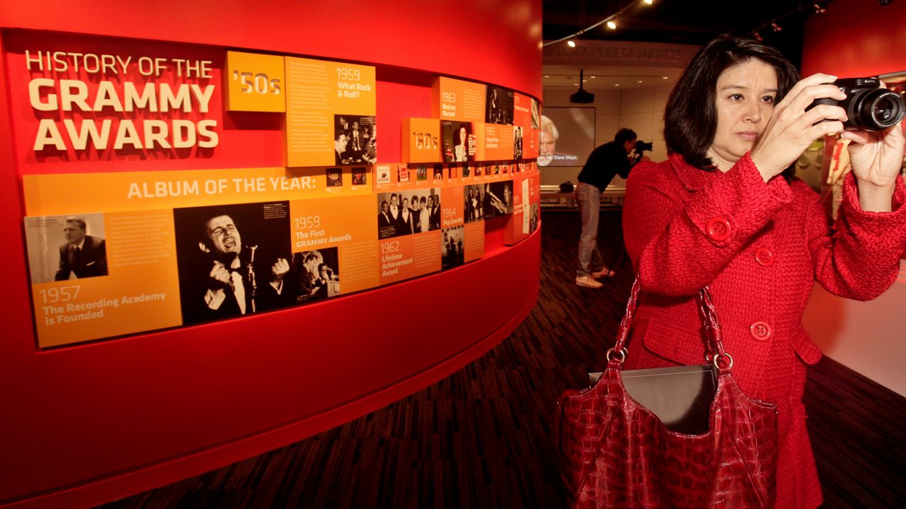 Alexandra Montoya photographs an exhibit at the Grammy Museum Tuesday, Dec. 2, 2008, in Los Angeles. (AP Photo/Ric Francis)