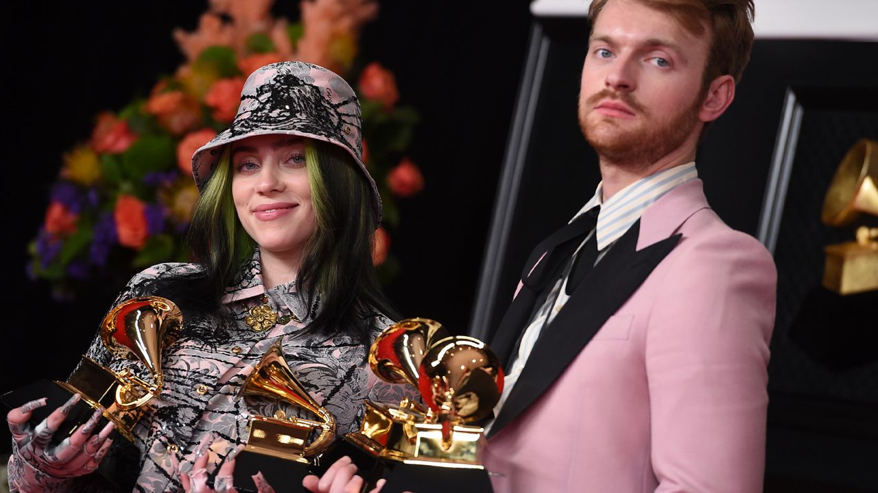 Finneas, right, and Billie Eilish pose in the press room with the awards for best song written for visual media and record of the year at the 63rd annual Grammy Awards at the Los Angeles Convention Center on Sunday, March 14, 2021. (Photo by Jordan Strauss/Invision/AP)
