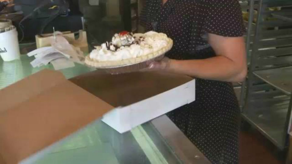A woman holds a pie above an open box. (Spectrum News file image)