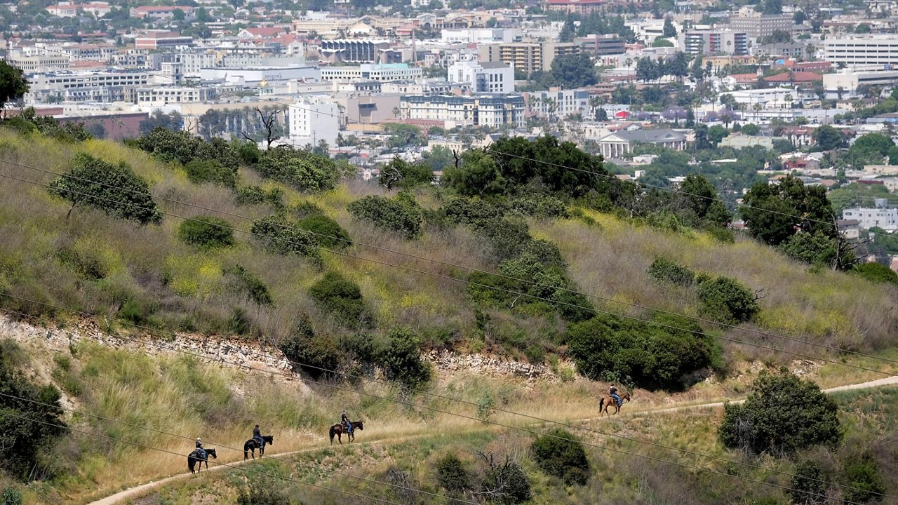 Riders on horseback advance down recently reopened hiking trails inside Griffith Park, Thursday, May 14, 2020, in Los Angeles. (AP Photo/Chris Pizzello)