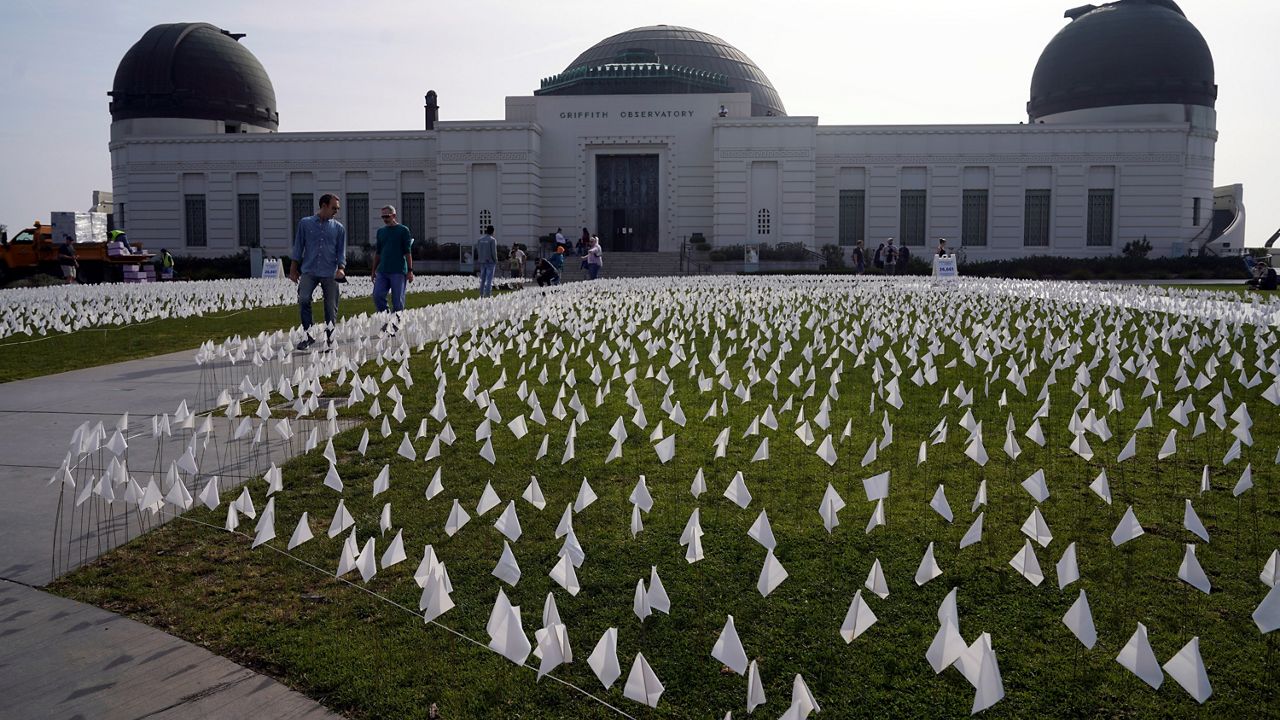 Flags are placed on the lawn at a memorial for victims of COVID-19 at the Griffith Observatory, Friday, Nov. 19, 2021, in Los Angeles.
