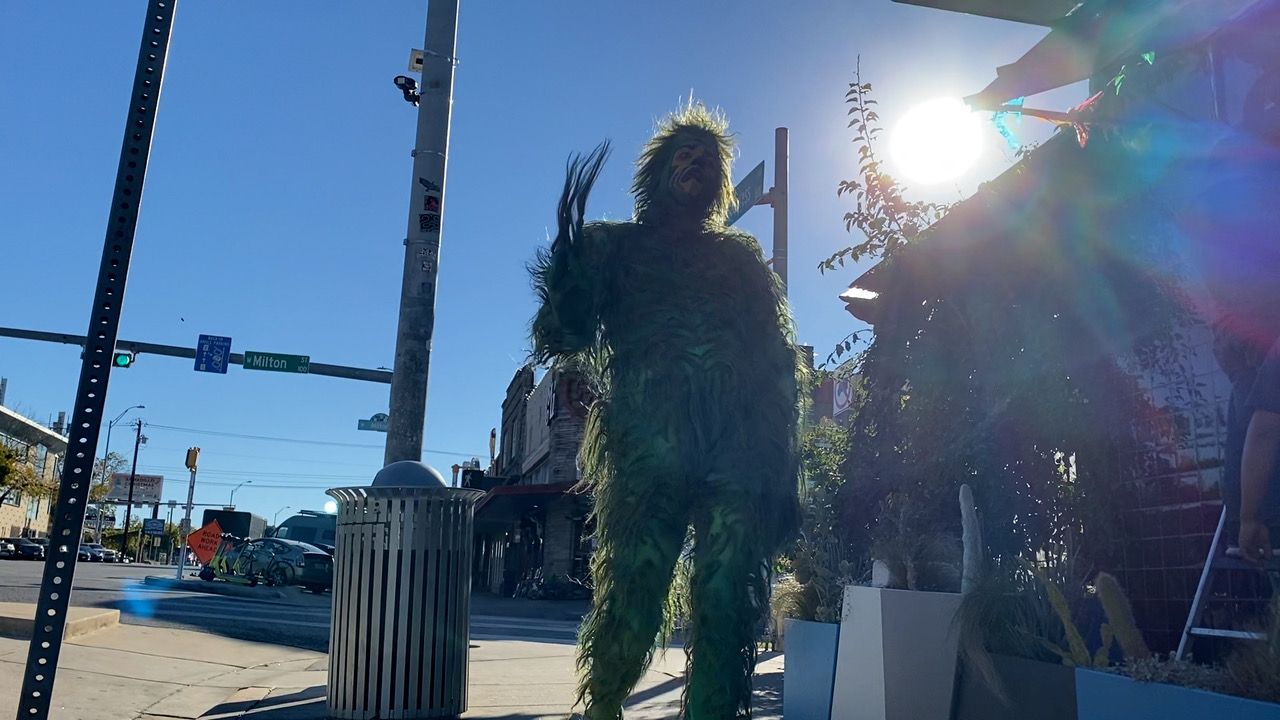 The Grinch standing at an intersection at South Congress