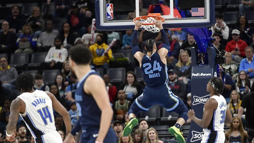 Washington Wizards' Kristaps Porzingis (6) makes a move to the basket  against Orlando Magic's Gary Harris (14) during the first half of an NBA  basketball game, Tuesday, March 21, 2023, in Orlando