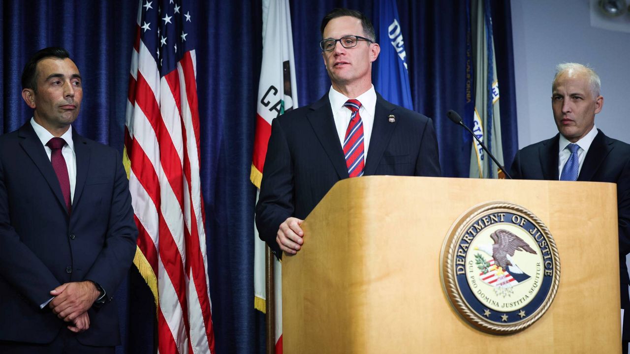 U.S. Attorney Randy S. Grossman for the Southern District of California, center, speaks during a press conference at the U.S. Attorney's Office for the Southern District of California on Thursday in San Diego. (Meg McLaughlin/The San Diego Union-Tribune via AP)