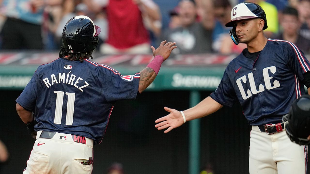 Cleveland Guardians' José Ramírez (11) is congratulated by Andrés Giménez after scoring in the second inning of the team's baseball game against the Toronto Blue Jays, Friday, June 21, 2024, in Cleveland.