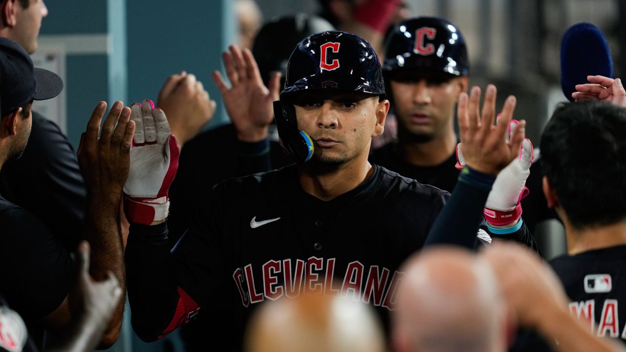 Cleveland Guardians' Andrés Giménez celebrates in the dugout after hitting a home run during the sixth inning of a baseball game against the Los Angeles Dodgers in Los Angeles, Friday, Sept. 6, 2024. Brayan Rocchio also scored.