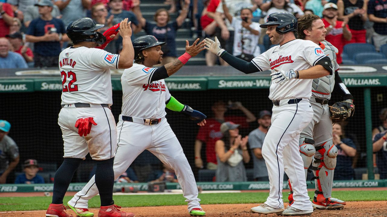 Cleveland Guardians' Josh Naylor (22) and Jose Ramirez, second from left, congratulate David Fry, front right, after Fry's three-run home run off Baltimore Orioles starting pitcher Trevor Rogers as Orioles catcher Adley Rutschman, back right, stands behind during the third inning of a baseball game in Cleveland, Thursday, Aug. 1, 2024. (AP Photo/Phil Long)