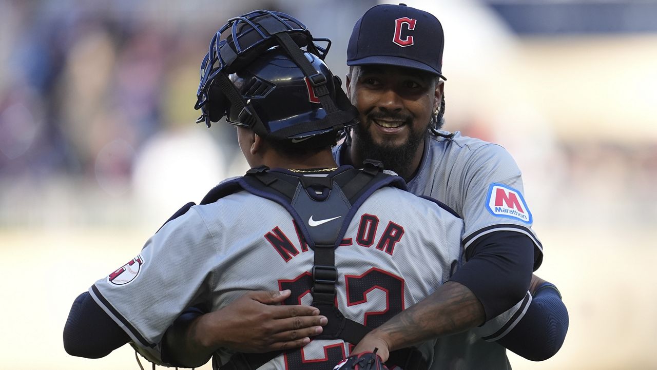 Cleveland Guardians catcher Bo Naylor (23) and relief pitcher Emmanuel Clase, right, hug after their win over the Minnesota Twins of a baseball game Thursday, April 4, 2024, in Minneapolis. (AP Photo/Abbie Parr)