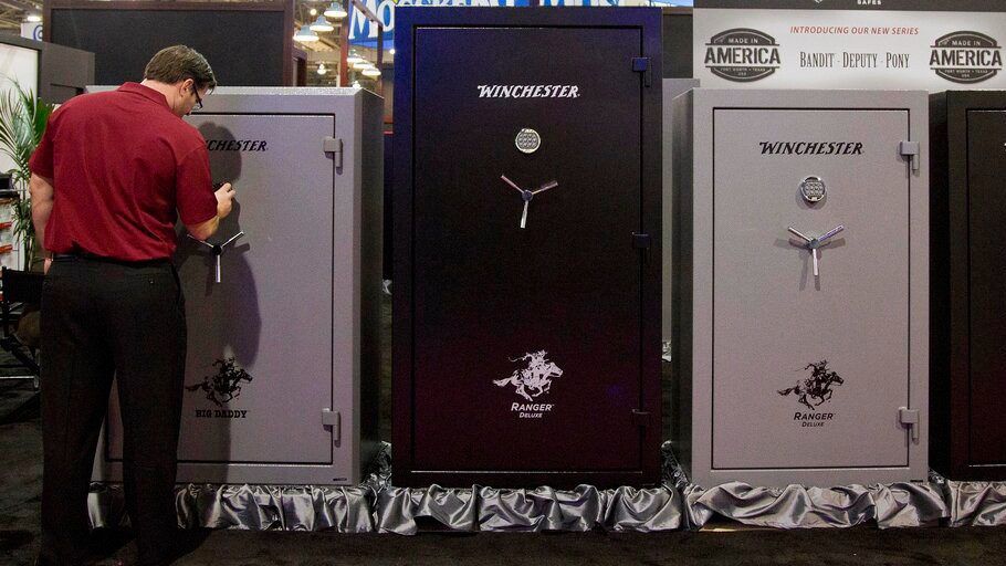 A Winchester Safes representative sets the lock on one of several gun safes on display at the 35th annual SHOT Show in this 2013 file photo. (AP Photo, File/Julie Jacobson)