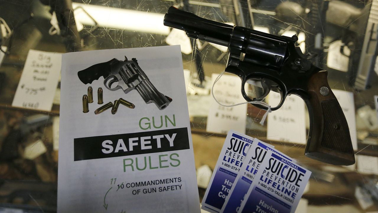 Gun safety and suicide prevention brochures are on display next to guns for sale at a retail gun store in Montrose Colo. (AP Photo/Brennan Linsley, File)