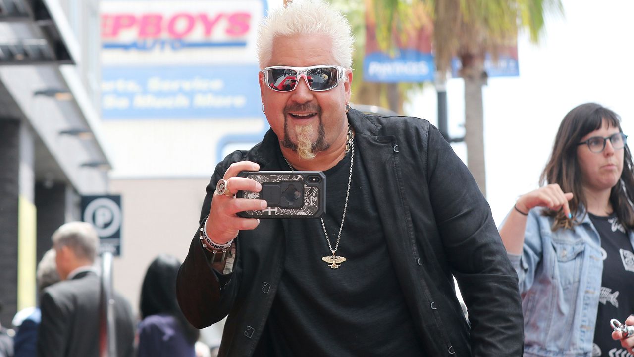 Guy Fieri takes a photo at the members of the press as he arrives at a ceremony honoring him with a star at the Hollywood Walk of Fame on Wednesday, May 22, 2019, in Los Angeles. (Photo by Willy Sanjuan/Invision/AP)