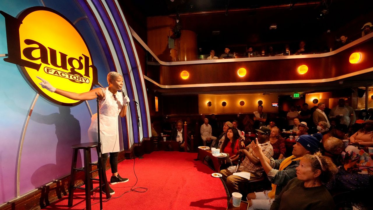 Stand-up comedian and actress Tiffany Haddish, left, entertains guests at Laugh Factory Hollywood, which provided free Thanksgiving meals Thursday, Nov. 23, 2023, in Los Angeles. (AP Photo/Damian Dovarganes)