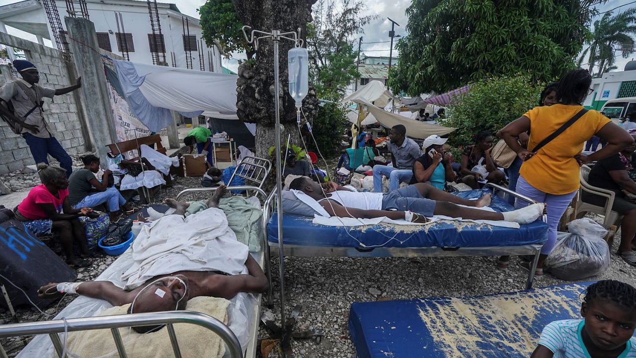 Injured people lie in beds outside the Immaculée Conception hospital in Les Cayes, Haiti, two days after a 7.2-magnitude earthquake struck the southwestern part of the country. (AP/Fernando Llano)
