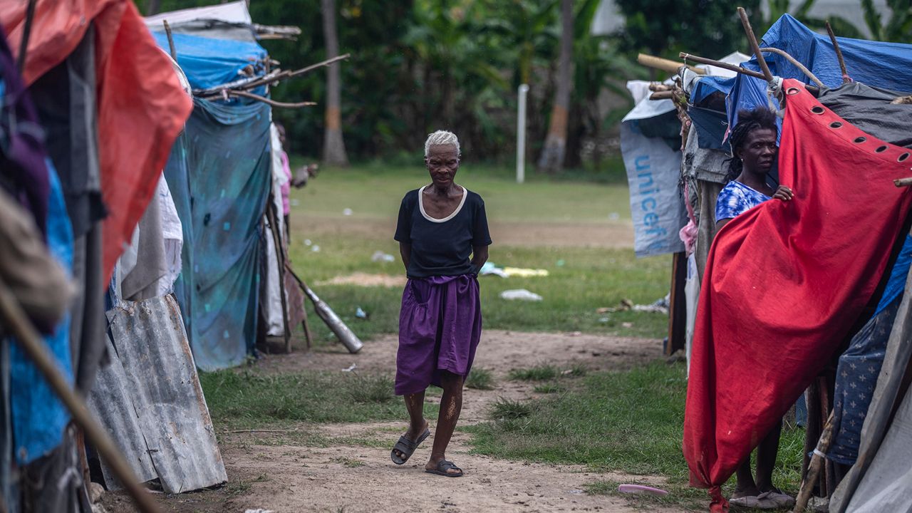 A resident walks through Camp Masse set up by people left homeless by last year’s 7.2-magnitude earthquake, in Les Cayes, Haiti, Wednesday, Aug. 17, 2022. Residents have complained that no government official had visited them despite repeated promises that they would come to help. (AP Photo/Odelyn Joseph)