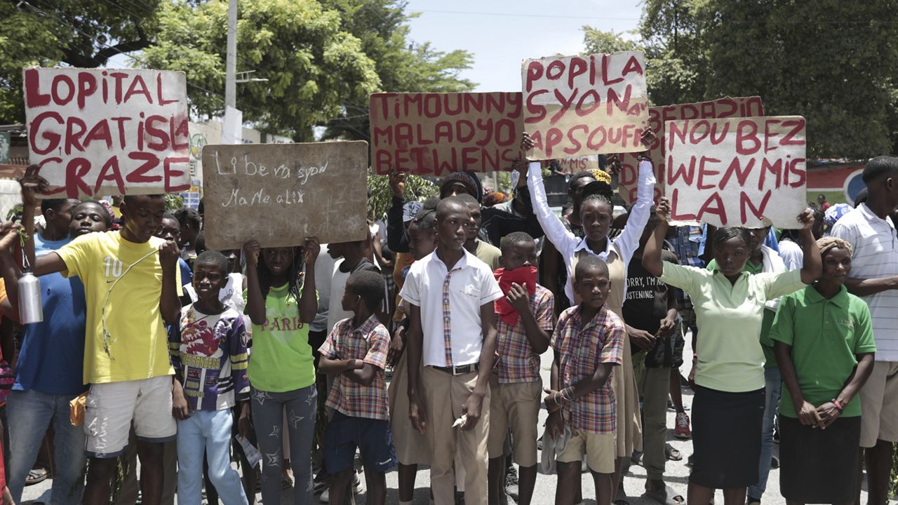 Students from the El Roi academy carry signs during a demonstration Monday to demand the freedom of New Hampshire nurse Alix Dorsainvil and her daughter, who have been reported kidnapped, in the Cite Soleil neighborhood of Port-au-Prince, Haiti. (AP Photo/Odelyn Joseph)