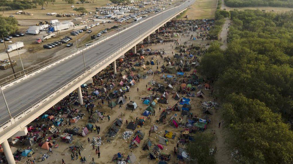 Migrants, many from Haiti, are seen at an encampment along the Del Rio International Bridge near the Rio Grande, Tuesday, Sept. 21, 2021, in Del Rio, Texas. The options remaining for thousands of Haitian migrants straddling the Mexico-Texas border are narrowing as the United States government ramps up to an expected six expulsion flights to Haiti and Mexico began busing some away from the border. (AP Photo/Julio Cortez)