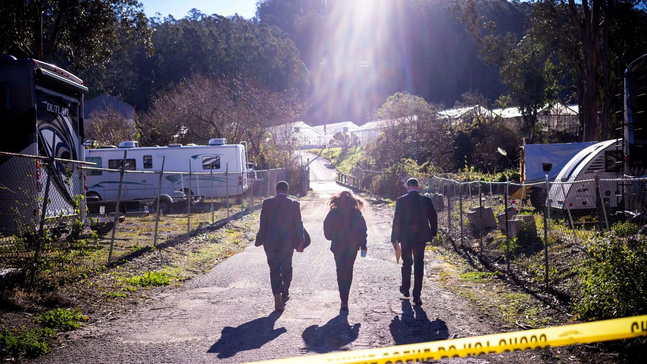 FBI officials walk towards the crime scene at Mountain Mushroom Farm Tuesday after a gunman killed several people at two agricultural businesses in Half Moon Bay, Calif. (AP Photo/Aaron Kehoe)