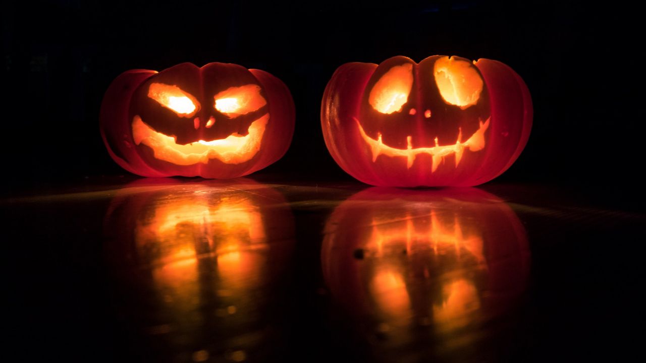 Scary ghost with halloween candy bucket and glowing Jack o lantern