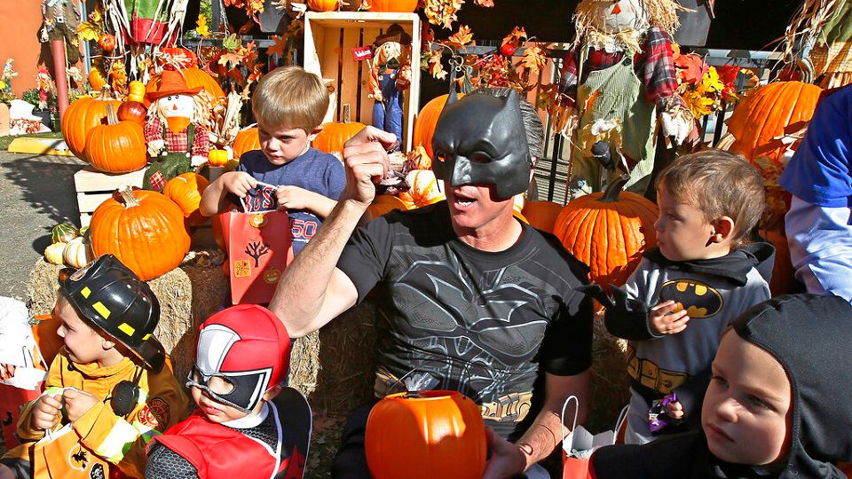 FILE - In this Oct. 31, 2018 file photo, then-Lt. Gov. Gavin Newsom, dressed as Batman, gets into the Halloween spirit as he hands out Halloween treats to costumed children during his visit to The Penleigh Child Development Center in Sacramento, Calif. (AP Photo/Rich Pedroncelli, File)